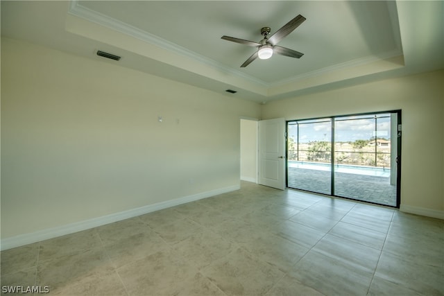 unfurnished room featuring ceiling fan, a tray ceiling, and light tile floors