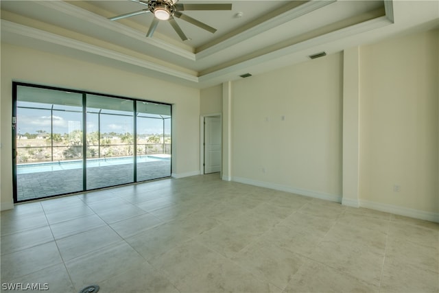 unfurnished room featuring light tile floors, crown molding, ceiling fan, and a raised ceiling