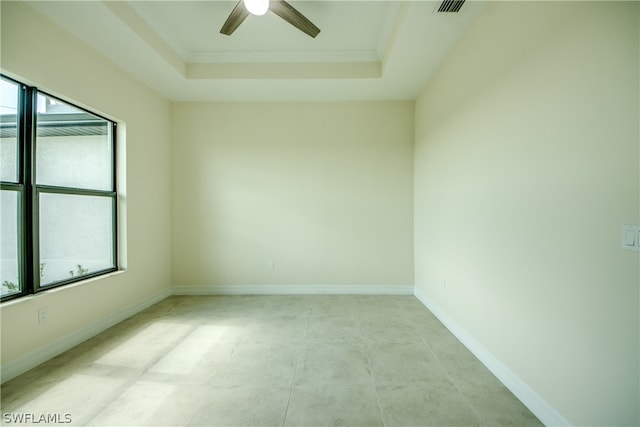 unfurnished room featuring tile flooring, ceiling fan, and a raised ceiling