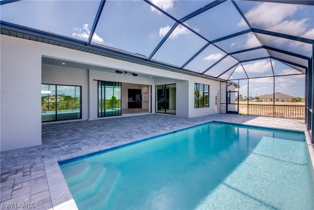 view of pool featuring a patio area, ceiling fan, and a lanai