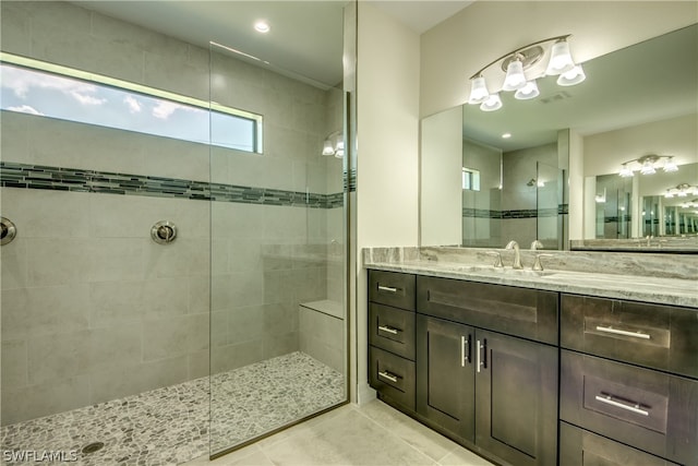 bathroom featuring a shower with door, vanity with extensive cabinet space, and tile floors