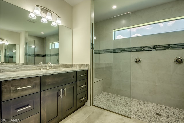 bathroom with vanity, tile floors, and a tile shower