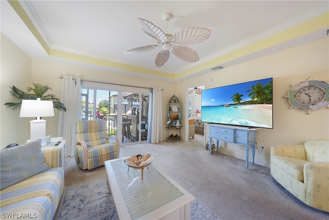 carpeted living room featuring crown molding, ceiling fan, and a raised ceiling