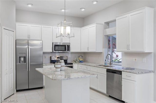 kitchen with backsplash, stainless steel appliances, sink, and a kitchen island