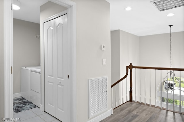 corridor featuring washing machine and dryer and light tile flooring