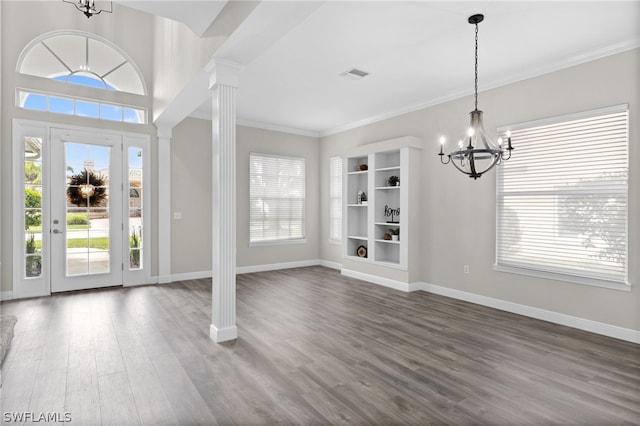 entrance foyer with ornate columns, hardwood / wood-style flooring, a chandelier, and ornamental molding