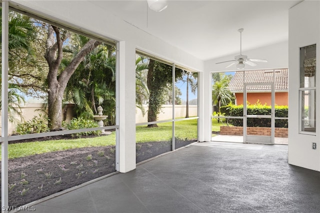 unfurnished sunroom featuring lofted ceiling, ceiling fan, and a wealth of natural light