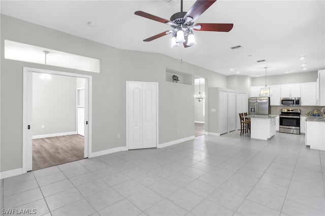 unfurnished living room with ceiling fan with notable chandelier and light tile floors