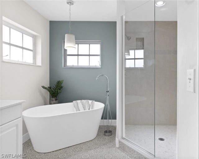 bathroom featuring tile flooring, vanity, and shower with separate bathtub