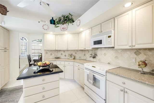 kitchen featuring white appliances, white cabinets, light stone countertops, tasteful backsplash, and light tile patterned flooring