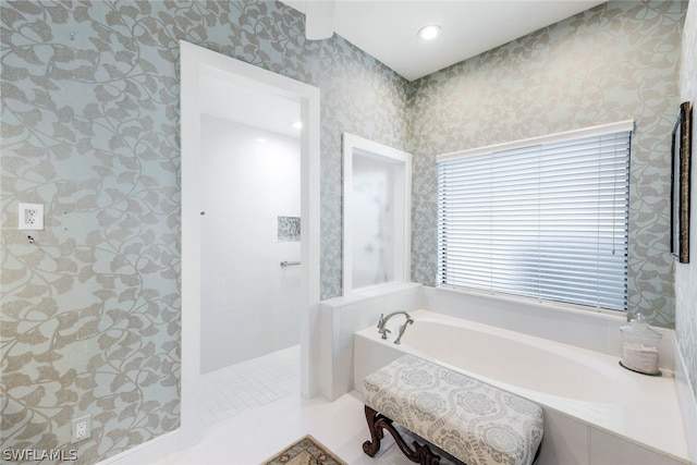 bathroom with tile patterned floors and shower with separate bathtub