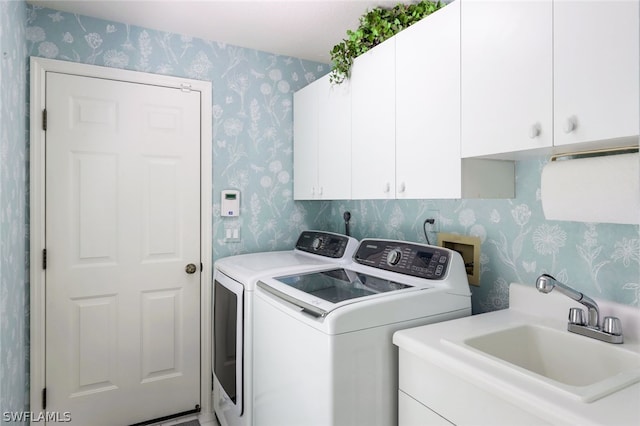 laundry room featuring cabinets, washing machine and dryer, and sink