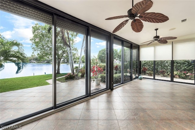 unfurnished sunroom featuring ceiling fan and a water view