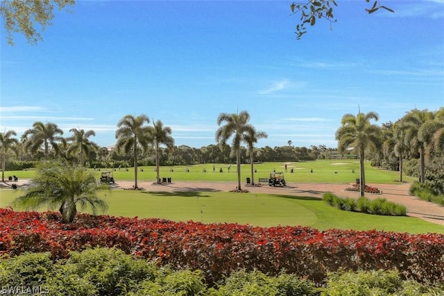 view of home's community featuring view of golf course and a lawn