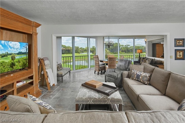 living room featuring a textured ceiling, stone finish flooring, and plenty of natural light