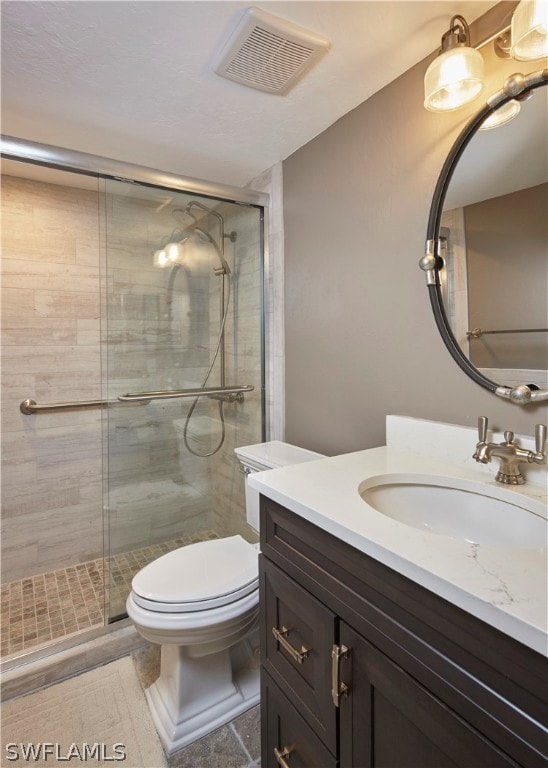 full bathroom with toilet, a shower stall, visible vents, and vanity