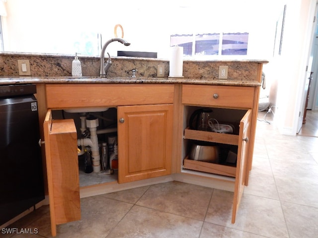 kitchen featuring light stone countertops, light tile patterned floors, dishwasher, and sink