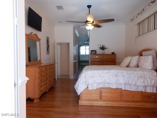 bedroom with hardwood / wood-style flooring, ceiling fan, and crown molding