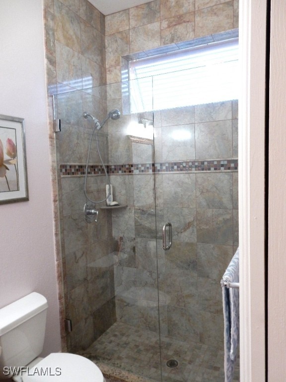 bathroom with walk in shower and toilet