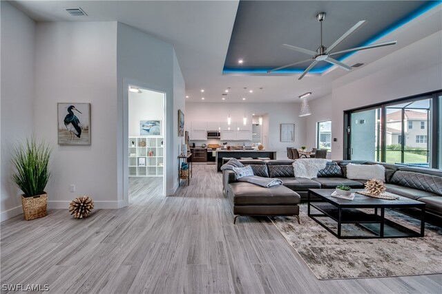 living room with ceiling fan and light wood-type flooring