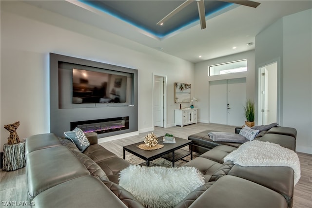 living room with ceiling fan and light wood-type flooring