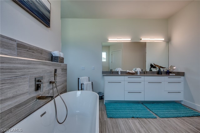 bathroom with vanity, hardwood / wood-style floors, and a tub