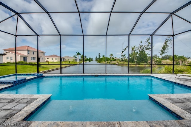 view of pool with glass enclosure and a lawn