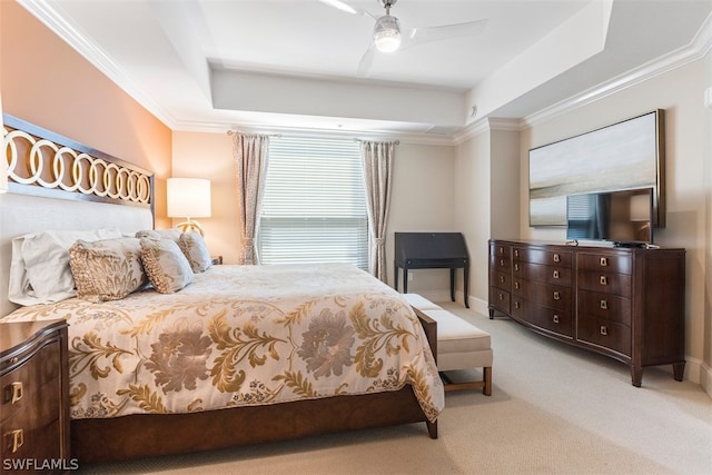 carpeted bedroom with ceiling fan, crown molding, and a tray ceiling