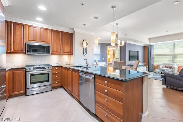 kitchen featuring pendant lighting, sink, appliances with stainless steel finishes, tasteful backsplash, and kitchen peninsula