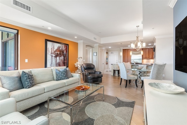 tiled living room featuring a chandelier and crown molding