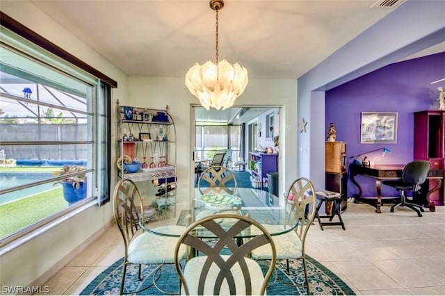 tiled dining room with a chandelier