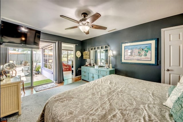 bedroom with wood-type flooring, ceiling fan, and access to exterior