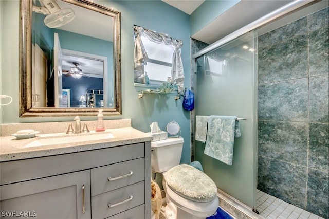 bathroom featuring walk in shower, toilet, oversized vanity, and ceiling fan