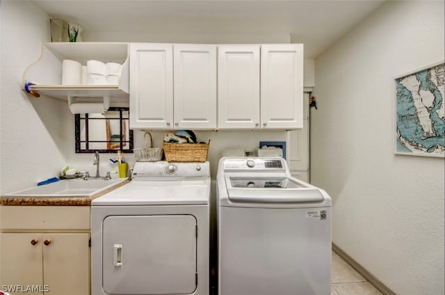 washroom featuring sink, washer and clothes dryer, cabinets, and light tile floors