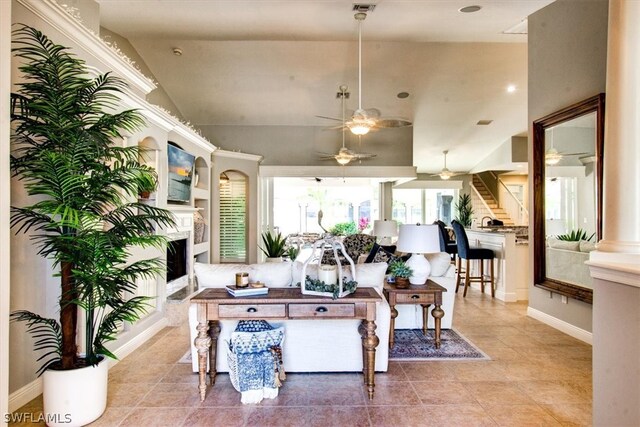 living room with high vaulted ceiling, ceiling fan, and light tile flooring