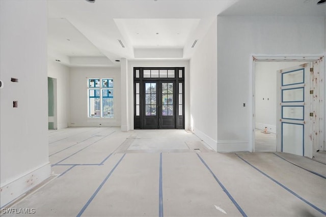 entrance foyer with french doors and a raised ceiling