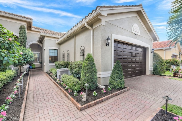 exterior space with a garage and central AC