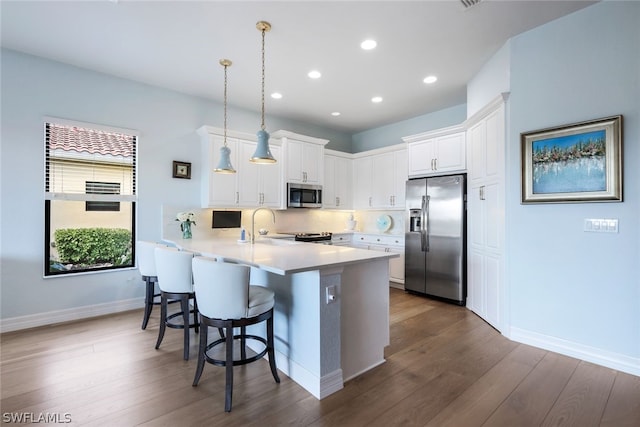 kitchen with decorative light fixtures, white cabinets, dark hardwood / wood-style floors, and stainless steel appliances