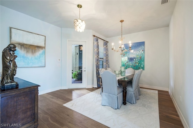 dining space with dark hardwood / wood-style floors and a notable chandelier