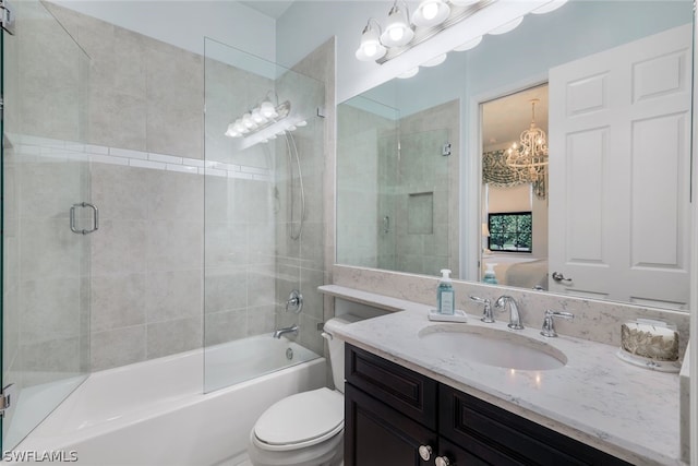 full bathroom with combined bath / shower with glass door, oversized vanity, toilet, and an inviting chandelier