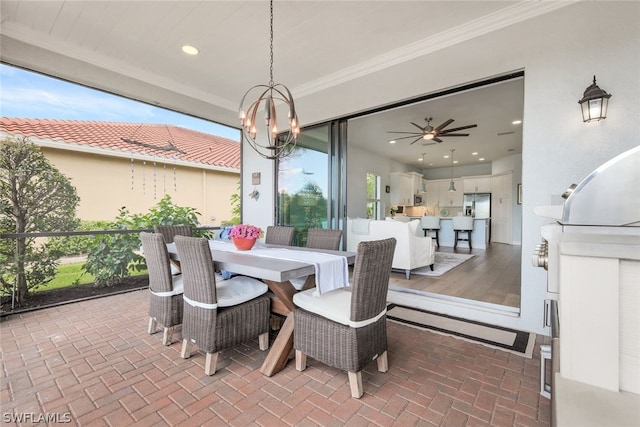 dining space with a wealth of natural light, ornamental molding, wood-type flooring, and ceiling fan with notable chandelier