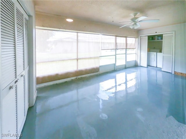 empty room featuring concrete flooring, a healthy amount of sunlight, ceiling fan, and washer and dryer