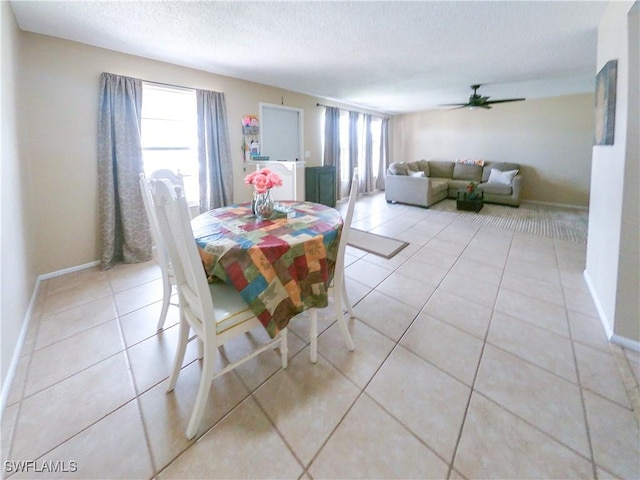 dining room featuring ceiling fan, plenty of natural light, light tile patterned flooring, and a textured ceiling