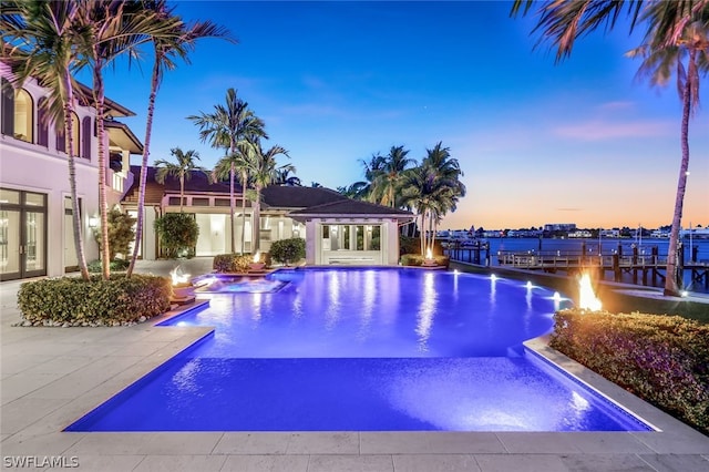 pool at dusk featuring a patio