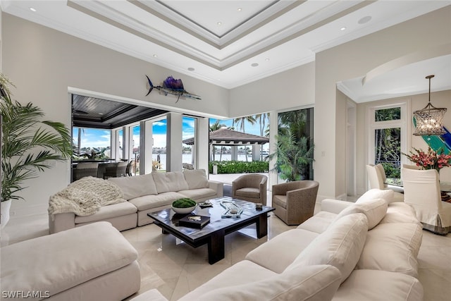 tiled living room with a high ceiling, ornamental molding, and a raised ceiling