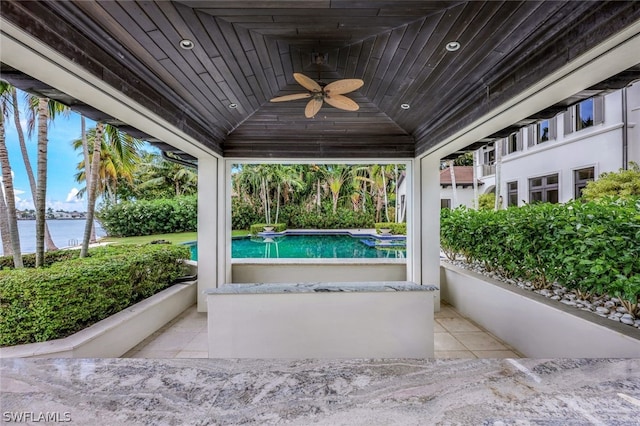 view of terrace with ceiling fan and a water view