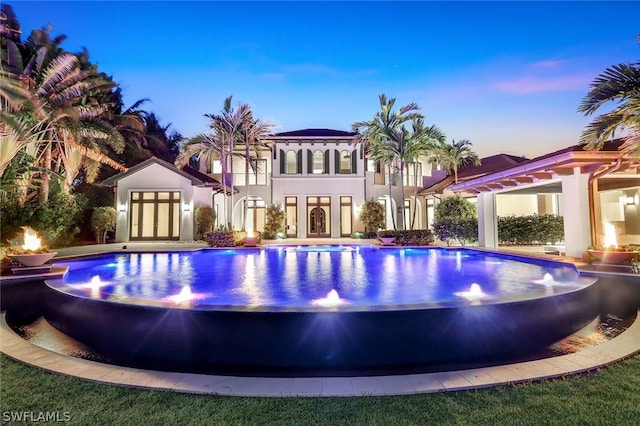 pool at dusk with french doors