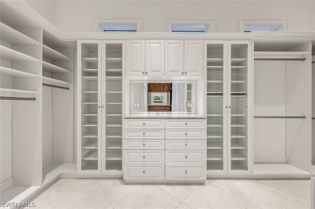 walk in closet with light tile floors