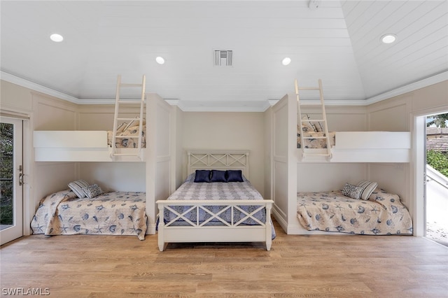 bedroom featuring ornamental molding, light hardwood / wood-style flooring, and vaulted ceiling