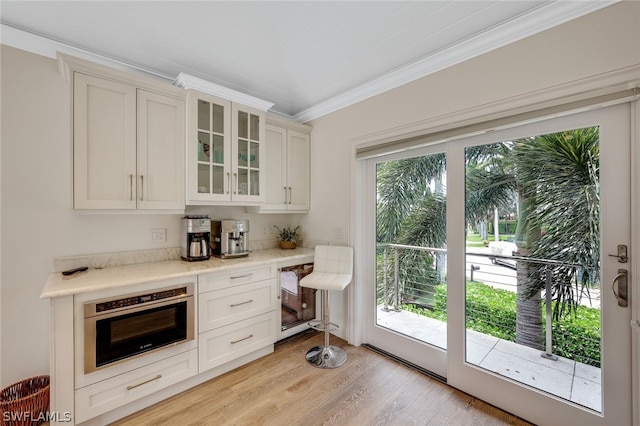 kitchen featuring oven, plenty of natural light, light hardwood / wood-style floors, and crown molding